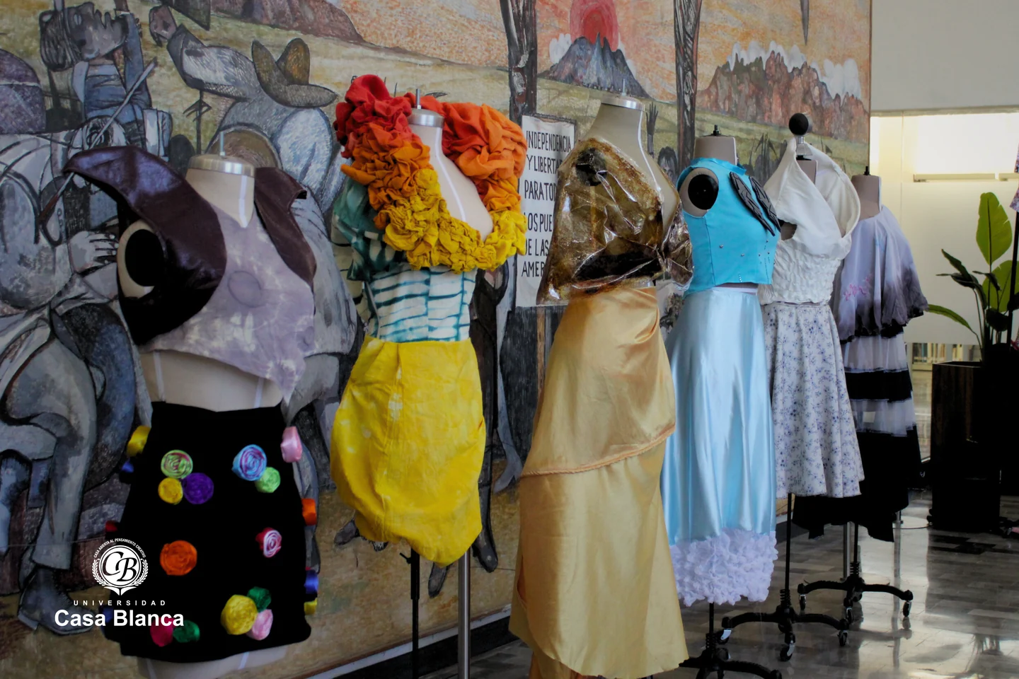 Maniquíes con vestidos de diferentes colores en un espacio de exposición